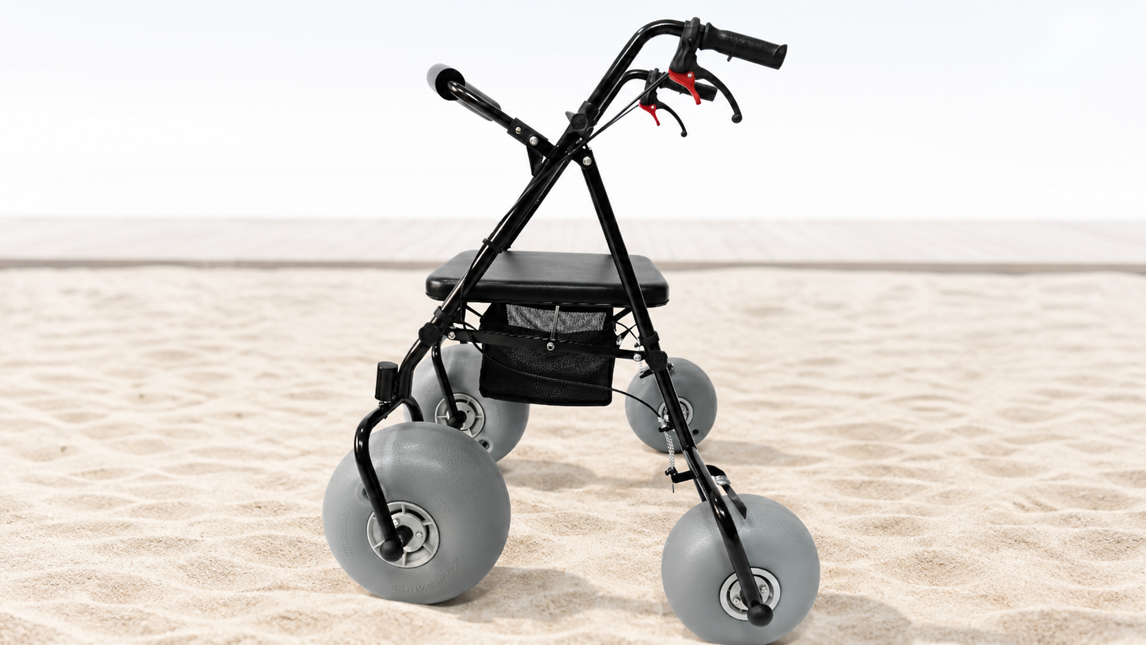 Original-style black four-wheel beach walker ready on pale sand beside a subtle boardwalk edge